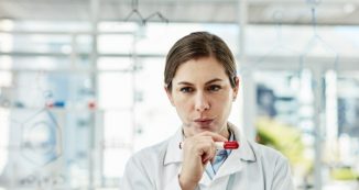 a woman in a lab coat contemplating
