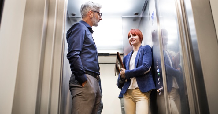 a man and a woman in an elevator having a conversation